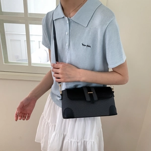 Fashionable crossbody bag with woven texture and gold hardware worn by a model
