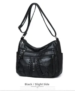 Detail view of black faux leather crossbody bag with multiple zippers and woven texture