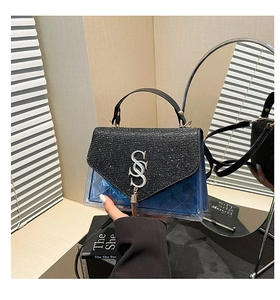 Detail der Glitzerklappe mit silbernem S-Logo und blauem transparentem PVC-Steppdesign