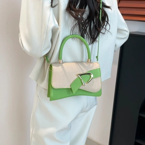 Close-up of elegant beige woven texture and green leather flap with gold D-buckle detail