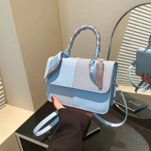 Chic light blue patchwork handbag with scarf-wrapped handle and adjustable shoulder strap