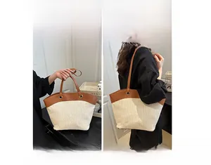 Detail of hand-woven straw tote bag with brown leather handles for shoulder or hand carry