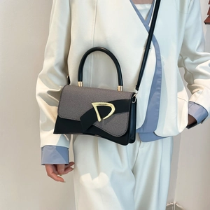 Detail of grey textured fabric handbag with black leather trim and golden D buckle