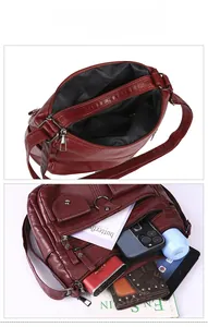 Internal view of burgundy crossbody bag showing multi-pocket capacity and daily essentials