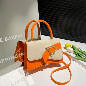 Detailed close-up of beige fabric and orange leather bag with golden D-ring buckle