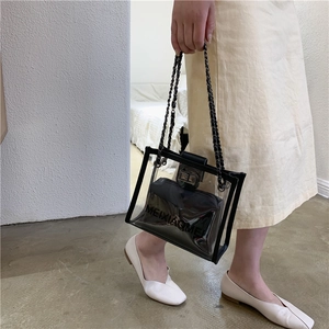 Transparent PVC tote bag with black inner pouch and metallic chain strap on model