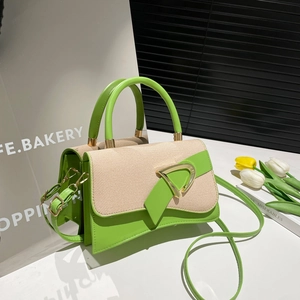 Detail of green leather trim and beige woven texture on a stylish flap crossbody bag