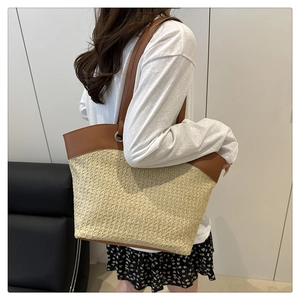 Detail showing the large woven straw tote bag with brown leather handles and side profile