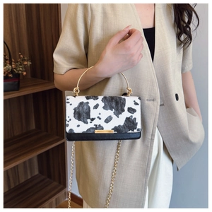Détail du sac à bandoulière en fausse fourrure motif vache avec poignée dorée ronde