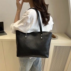 Close-up detail of the black woven texture and premium PU leather finish on this tote bag