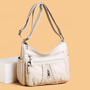 Minimalist soft white faux leather crossbody bag with woven details and multiple zippers
