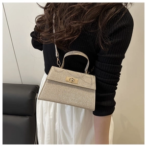 Close-up of sparkling rhinestone handbag featuring a gold turn-lock and metallic shine