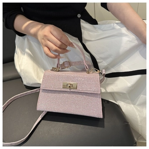 Detail of glittery pink-purple crossbody bag with gold metal twist lock closure