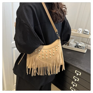 Detailopname van de camelkleurige crossbodytas met gouden noppen en franjes