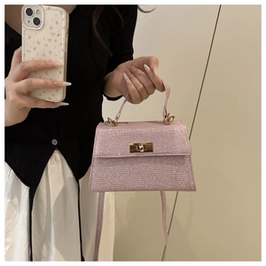 Close-up of pink glitter crossbody bag featuring a golden vintage twist lock detail