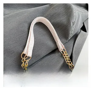 Detail of crocodile-embossed leather tote with elegant golden double chain handles