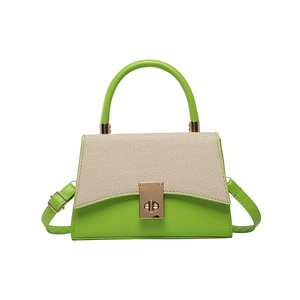 Green leather and beige canvas color-block handbag with golden metal lock and shoulder strap
