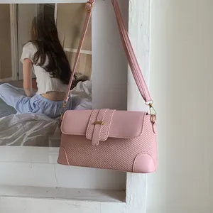 Close-up of pink shoulder bag featuring woven texture and smooth leather patchwork
