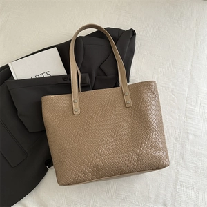 Detailed close-up of khaki woven texture and silver rivet hardware on tote bag