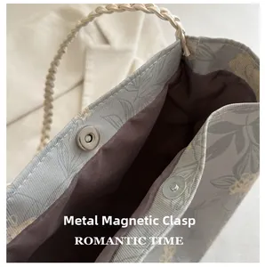 Detail of silver magnetic clasp and floral fabric lining on a large tote bag