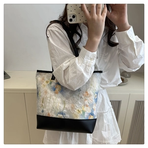 Detail of floral chiffon texture and black leather stitching on oversized tote bag