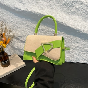 Detail of green leather and straw crossbody bag with golden D-buckle closure