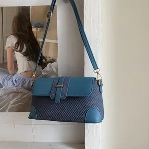 Detailed close-up of blue woven texture and leather patchwork on the crossbody bag