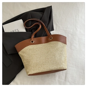 Detail of the woven straw texture and brown leather strap on a summer beach tote bag