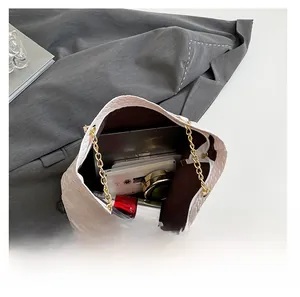 Interior view of white woven shoulder bag showing spacious storage for tablet and cosmetics