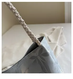 Detail of light blue floral tote bag with sturdy woven strap and fine stitching work