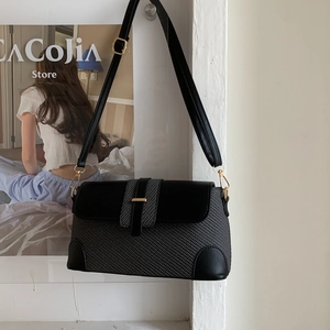 Detail of grey woven texture and black leather finish on a stylish rectangular handbag