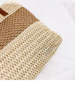 Detalle de la textura de ganchillo en el bolso de paja a rayas con borde de cuero