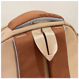 Detail of reinforced handle and breathable mesh on a contrast color nylon backpack