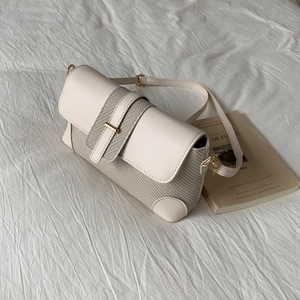 Detail of the woven texture and cream pebble leather stitching on this shoulder bag