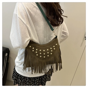 Detail of dark brown leather crossbody bag with metal rivets and long fringe tassels