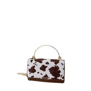 Mini sac femme imprimé vache avec poignée anneau doré et chaîne sur fond blanc