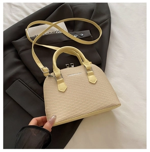 Detail of woven texture shell bag with silver double zipper and adjustable strap