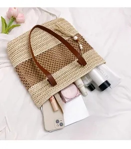 Primer plano del interior del bolso de paja que muestra capacidad para maquillaje y móvil