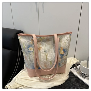 Detail of pink floral tote bag with textured plush fabric and premium leather handle