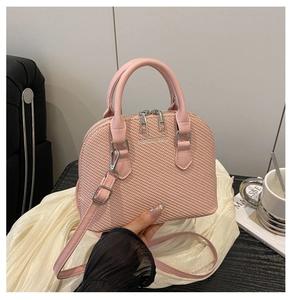 Detail of pink shell bag featuring woven texture and silver FASHION & BAGS metal logo