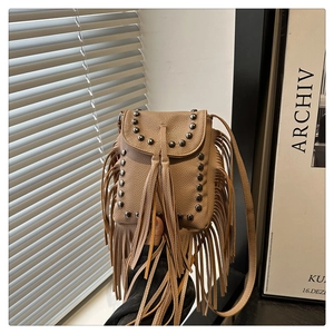 Detail of bohemian khaki tassel bag with studs and lychee pattern leather texture