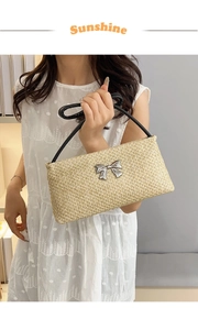 Détail du sac en paille tressé avec boucle en nœud métallique et poignée noire