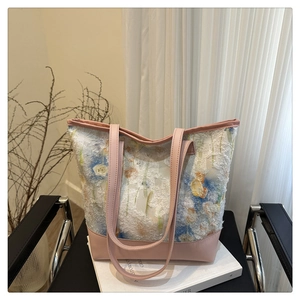 Detail of floral tapestry tote bag with textured fringe and pink leather straps
