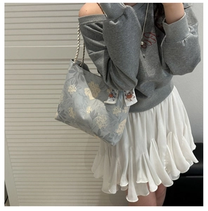 Close-up of gray floral tote bag with cotton rope handles and decorative scarf detail