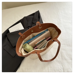 Interior view of a straw tote bag showing large capacity for umbrella, books and wallet