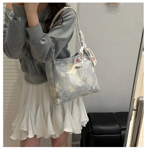 Floral print tote bag with braided handles and decorative silk scarf detail