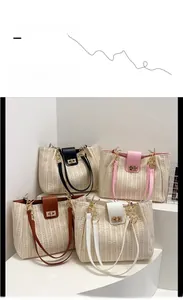 Detail view of woven straw tote bags in black pink brown and white with chain straps