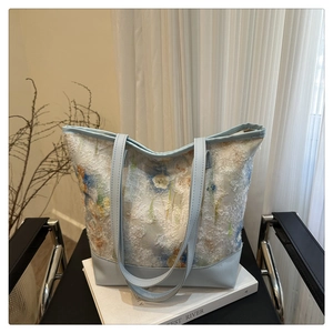 Close-up of floral jacquard tote bag with light blue leather straps on a chair