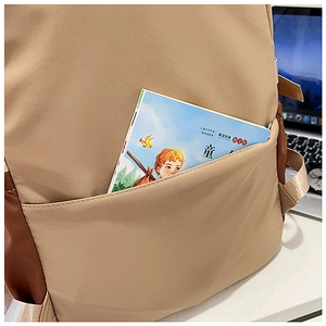 Close-up of side pocket storage with a book in khaki high-capacity campus backpack