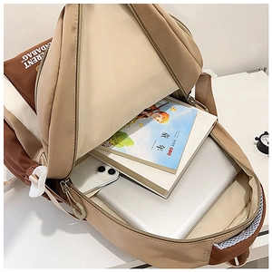 Detailed internal compartment of the color-block backpack showing laptop and books storage